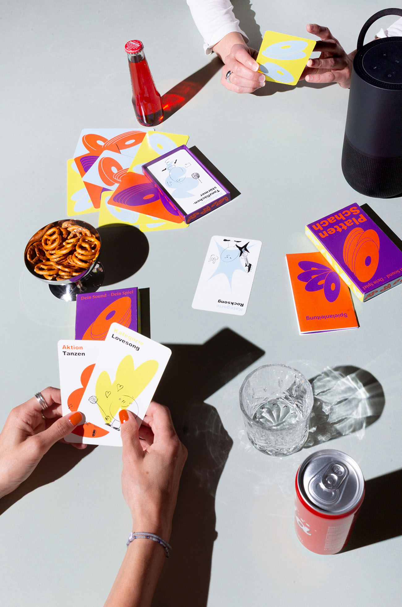 Eine gestellte Szene an einem Tisch mit Spielkarten und Snacks und Getränken